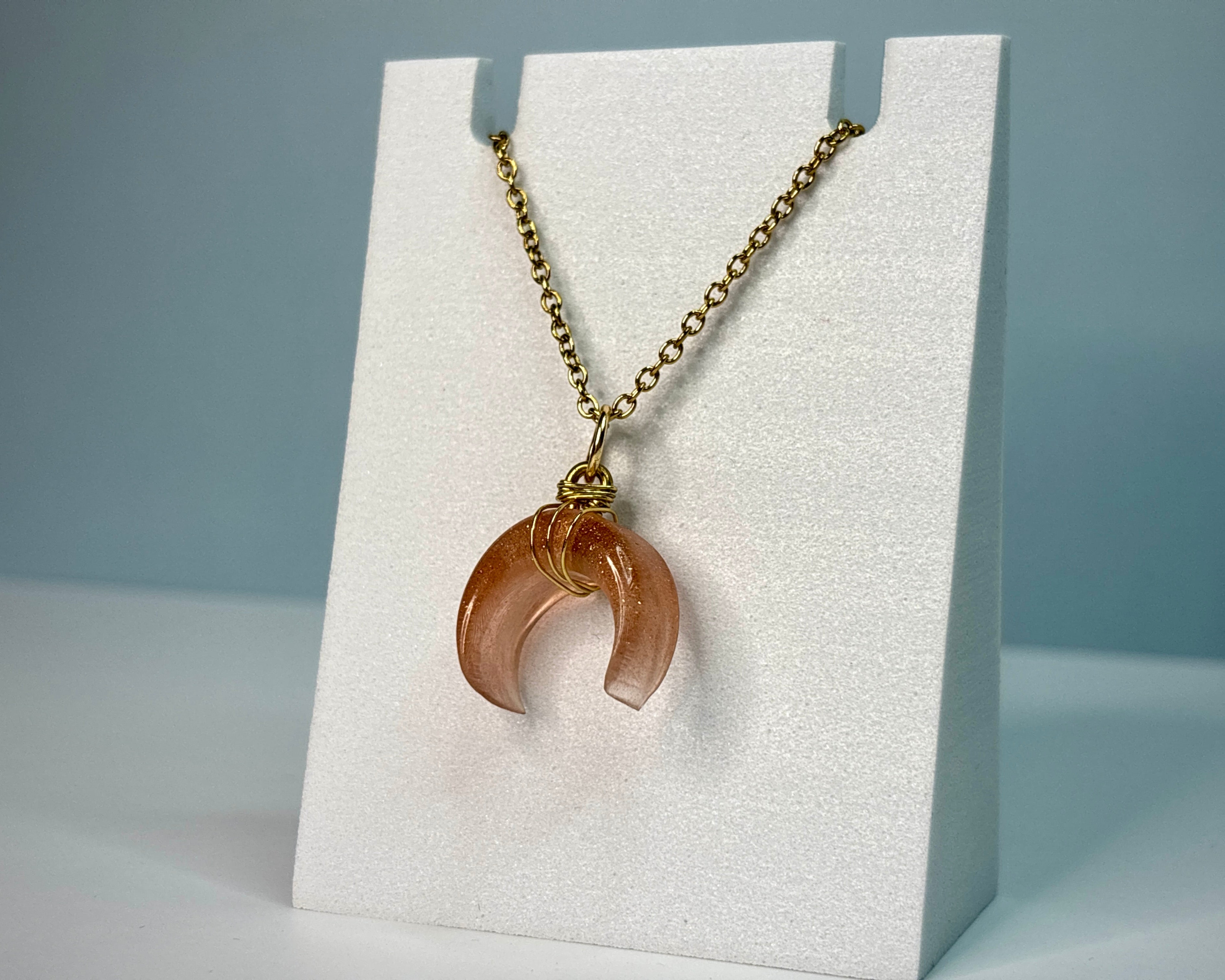 Necklace with a pendant on a white display card against a gray background