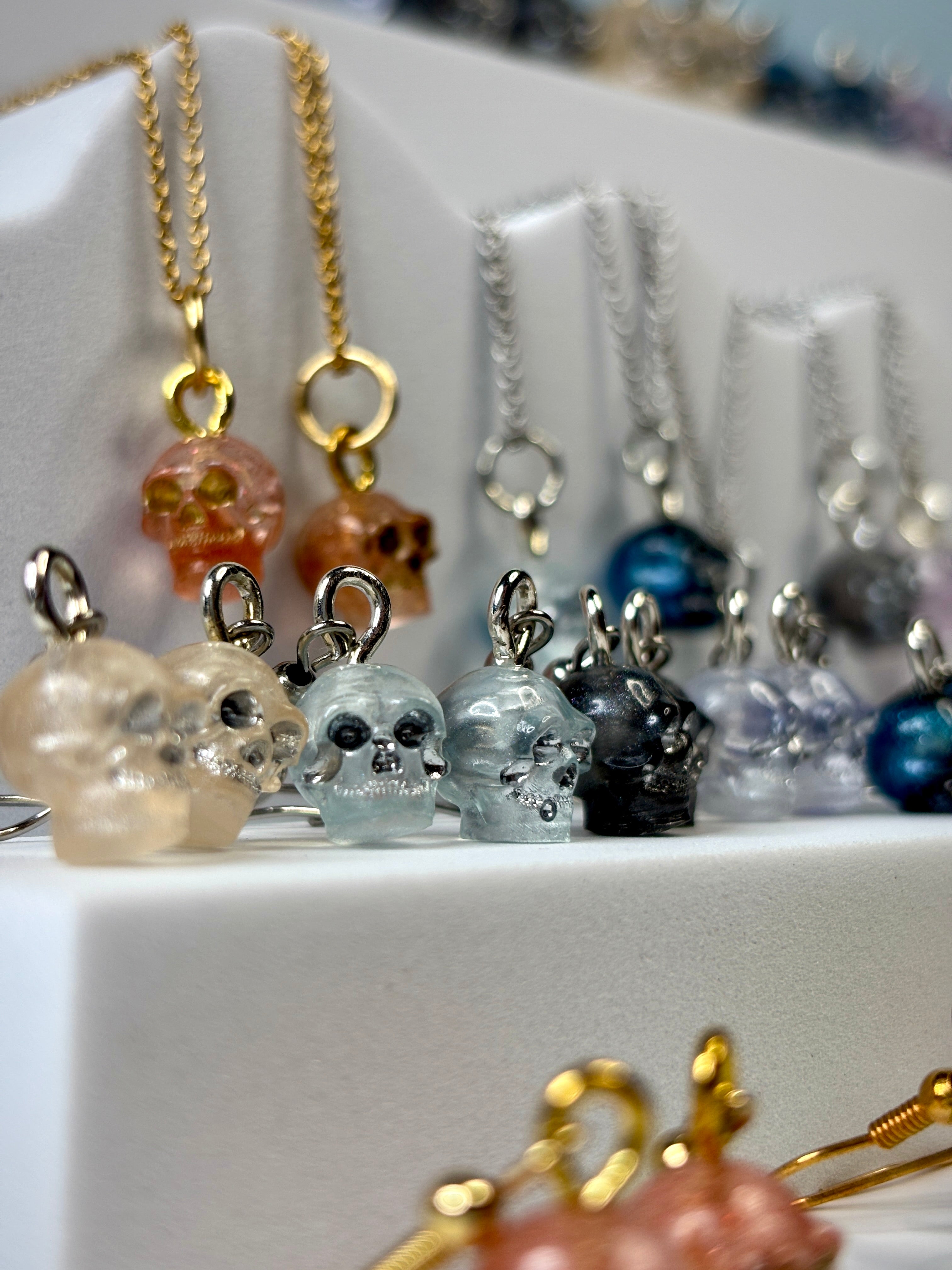Skull-shaped charms on necklaces with a blurred background