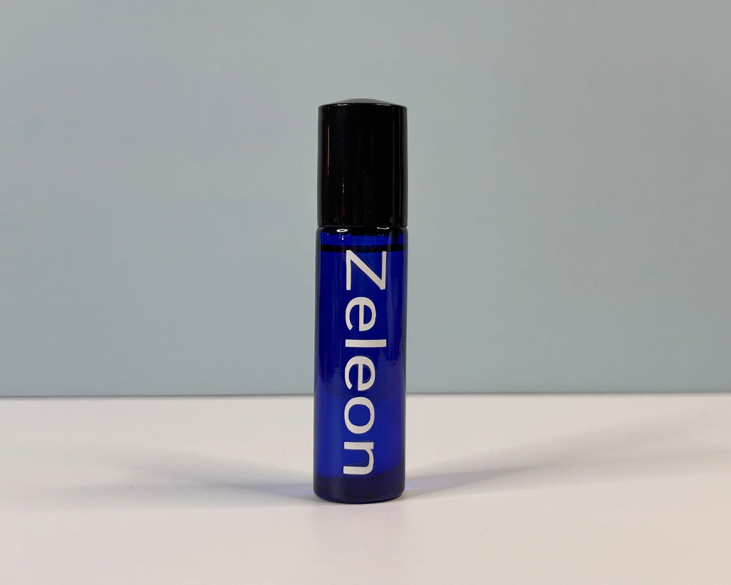 Blue rollerball bottle with black cap on a gray background