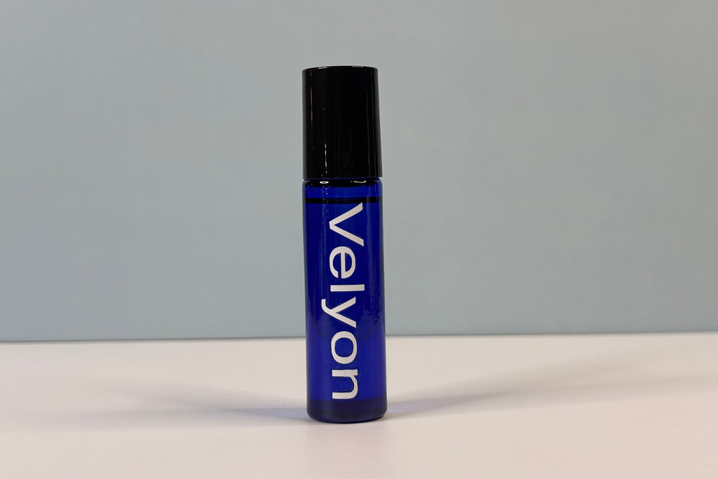 Blue rollerball bottle with black cap on a gray background